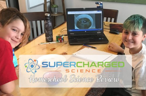 Two boys smiling as they work on a science experiment from Supercharged Science. you looking for a homeschool science program? Check out this review for Supercharged Science - an interactive science program with lots of experiments!