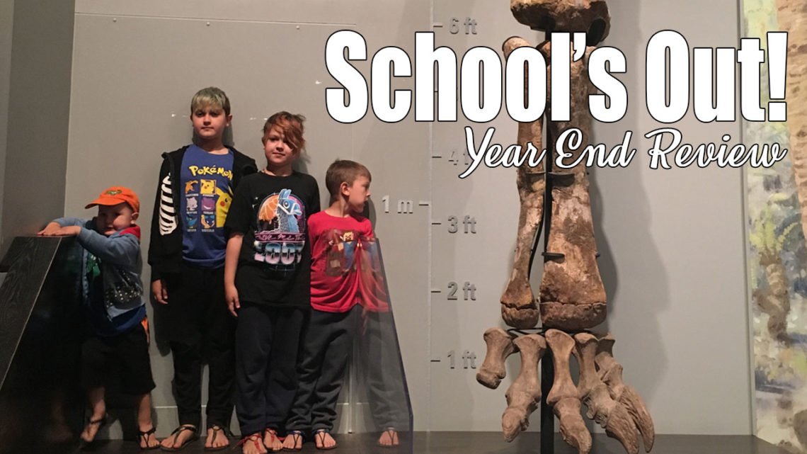 4 boys of different heights stand beside a size chart and a very large fossil of the leg and foot bones from a dinosaur. School's Out! It is summer and we are excited for warmer weather and new adventures. We just had our unschooling year-end meeting and are officially done!