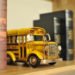 toy school bus sits on a shelf surrounded by old books