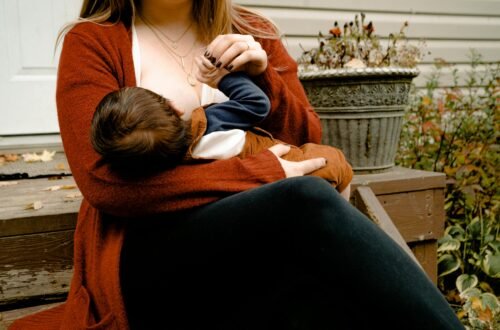 a woman sitting outside breastfeeding her baby